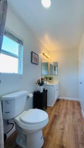 a white bathroom with a toilet and a sink at 4Bd Spacious Oasis near wineries in Menifee +52 photos