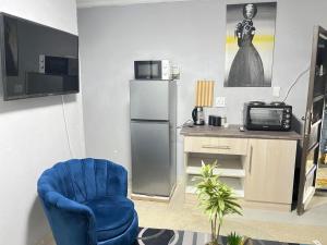a living room with a blue chair and a television at samama guesthouse in Groblersdal
