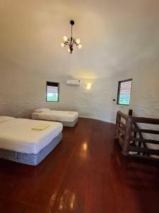 a room with two beds and a chandelier at บ้านดิน 2 ชั้น in Khanong Phra