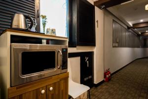 a kitchen with a microwave and a tv on a cabinet at Hotel Junoh in Seoul