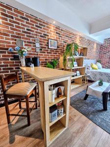 einen Tisch und Stühle in einem Zimmer mit Ziegelwand in der Unterkunft Beautiful loft 607 in Centro Historico Centro Vivo in Las Victorias