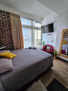 ein Schlafzimmer mit einem großen Bett und einem großen Fenster in der Unterkunft Beautiful loft 607 in Centro Historico Centro Vivo in Las Victorias