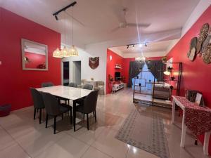 a dining room with red walls and a table and chairs at RedHouse Sky Garden Klabang in Ipoh