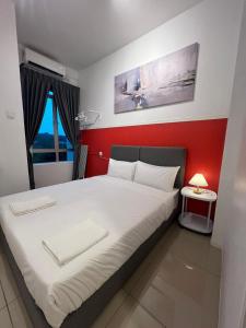 a bedroom with a bed with a red wall at RedHouse Sky Garden Klabang in Ipoh
