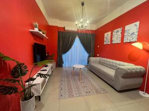 a living room with red walls and a couch and a table at RedHouse Sky Garden Klabang in Ipoh