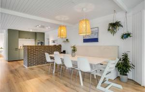 a dining room with a table and white chairs at Three-Bedroom Holiday Home In Ebeltoft in Ebeltoft