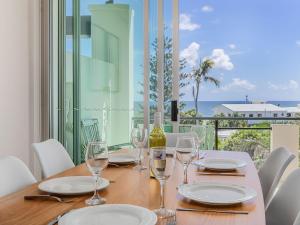 a table with wine glasses and a view of the ocean at Luxury Oceanfront Haven with a Private Rooftop Spa in Kingscliff