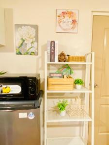 a kitchen shelf with plants and a microwave at FEELS LIKE HOMIE STAYCATION in Pasig City in Manila