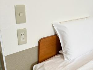 名護市にあるHotel Yamadaso - Vacation STAY 10193vの白い枕と電気のスイッチが付いたベッド