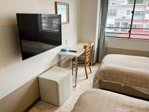 a bedroom with a bed and a tv on the wall at Hotel Yamadaso - Vacation STAY 10202v in Nago