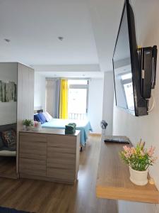 ein Schlafzimmer mit einem Bett und einem Fernseher an der Wand in der Unterkunft Modern Loft 511 in Centro Historico Centro Vivo in Las Victorias
