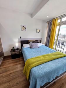 ein Schlafzimmer mit einem Bett mit einer gelben Decke darauf in der Unterkunft Modern Loft 511 in Centro Historico Centro Vivo in Las Victorias + 38 Fotos