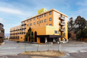 a yellow building with a sign on top of it at Select Inn Fujisan Gotemba in Gotemba