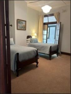 a bedroom with two beds and a window at The Riverine Club in Wagga Wagga