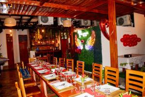 a dining room with tables and chairs and a painting of a chicken at HOTEL LA PALMERA DE ORO in Tarapoto
