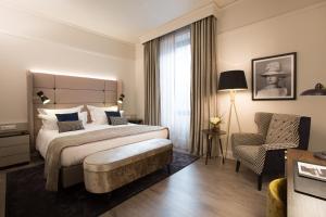 フィレンツェにあるHotel Cerretani Firenze - MGallery Collectionのベッドと椅子付きのホテルルーム