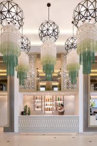 a lobby with two chandeliers and a counter at Dusit Princess Chiang Mai in Chiang Mai