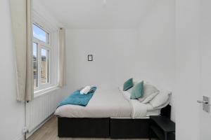 a bed in a room with a window at Startlet Stays Apartments - On Elizabeth Line with Free Parking in London