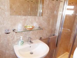 a bathroom with a sink and a shower at The Denewood in Sandown
