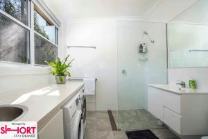 un bagno bianco con lavandino e doccia di Paddington Villa 1 - Free Wi-fi, Netflix a Orange