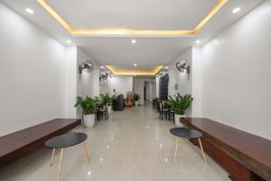 Un vestíbulo con dos bancos, mesas y sillas. en KLY Boutique Hotel Hue, en Hue