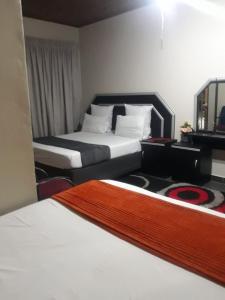 a hotel room with two beds and a mirror at Platinum inn pty ltd in Rustenburg