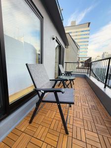 a balcony with two chairs on top of a building at SUN House asakusabashi akihabara tokyo in Tokyo