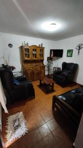 ein Wohnzimmer mit schwarzen Ledermöbeln und einem TV in der Unterkunft Dúplex Complejo “Poker” in Villa Gesell