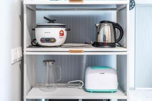 a shelf with a blender and other appliances on it at Jesselton Quay T2 by SNUG SPACE in Kota Kinabalu
