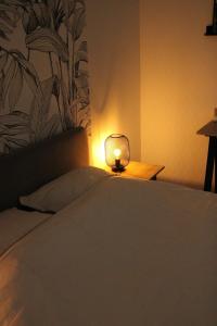 a bedroom with a bed with a lamp on it at Chez Jules, appartement tout confort de 40 m2 in Denain