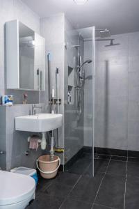 a bathroom with a shower and a sink and a toilet at Jesselton Quay T2 by SNUG SPACE in Kota Kinabalu