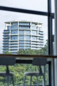 a large building is seen through a window at Jesselton Quay T2 by SNUG SPACE in Kota Kinabalu