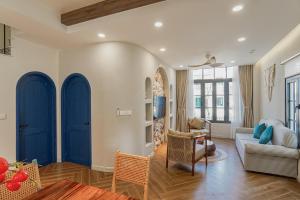 a living room with blue doors and a couch at Nhà A Trí in Bình Tú