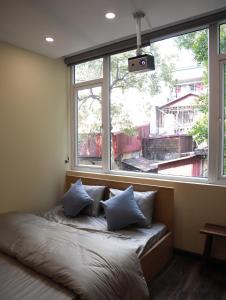 een bed in een kamer met een groot raam bij ONCÊ LIVING and COFFEE in Hanoi
