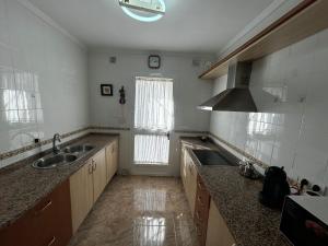 a large kitchen with a sink and a window at chalet adosado La morena cerca del caminito del rey in Ardales