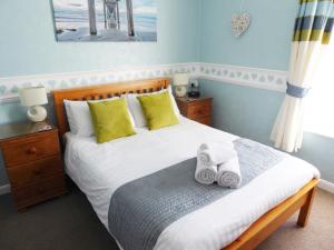 a bedroom with a bed with towels on it at The Denewood in Sandown
