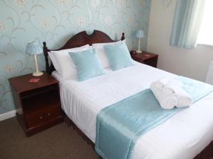 a bedroom with a bed with towels on it at The Denewood in Sandown