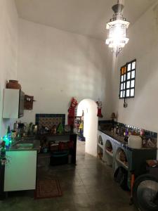 Una habitación grande con cocina y lámpara de araña. en Casa Historica Colonial, en Álamos