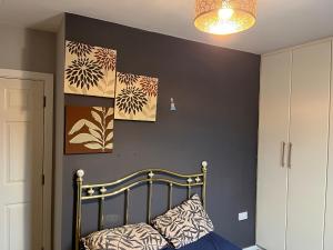 a bedroom with a black wall with paintings on it at Bettys master bedroom in Stockton-on-Tees