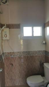 a bathroom with a toilet and a window at M-Plus Homestay Sukhothai in Sukhothai +15 photos