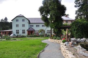 a large white house with a walkway in front of a yard at Hotel Rudka in Kunštát
