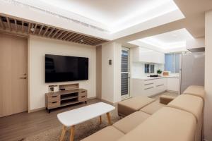 a living room with white furniture and a flat screen tv at 2B1bLDK Zhongxiao Dunhua, Ultra Center City • 2房1衛 客廳廚房 忠孝敦化 黃金地段市中心 in Taipei