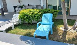 Eine Gruppe blauer Stühle steht neben einem Baum in der Unterkunft Villa Ge in Ursulo Galván