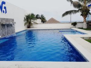 ein Schwimmbecken mit blauem Wasser und Palmen in der Unterkunft Villa Ge in Ursulo Galván