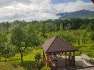 a gazebo with a bench in a field at Casa Maria in Sarmizegetusa