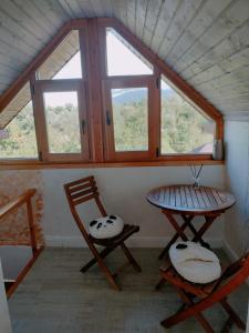 a room with two chairs and a table and two windows at Casa Maria in Sarmizegetusa