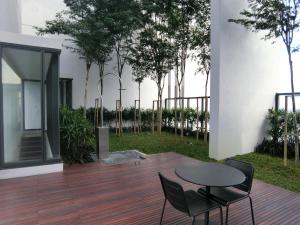 un patio con mesa y sillas en una terraza de madera en The Altus -Icon City Petaling Jaya, en Petaling Jaya