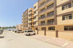a white van parked in front of a building at Beautiful Salalah Beach Apartments - 3 By Beautiful Salalah Tours in Salalah