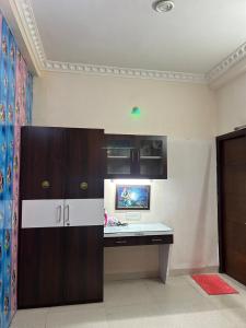 een kamer met een bureau en een kast in een kamer bij Indore Home stay in Indore