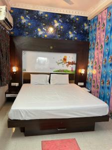 een slaapkamer met een groot bed en een sterrenplafond bij Indore Home stay in Indore